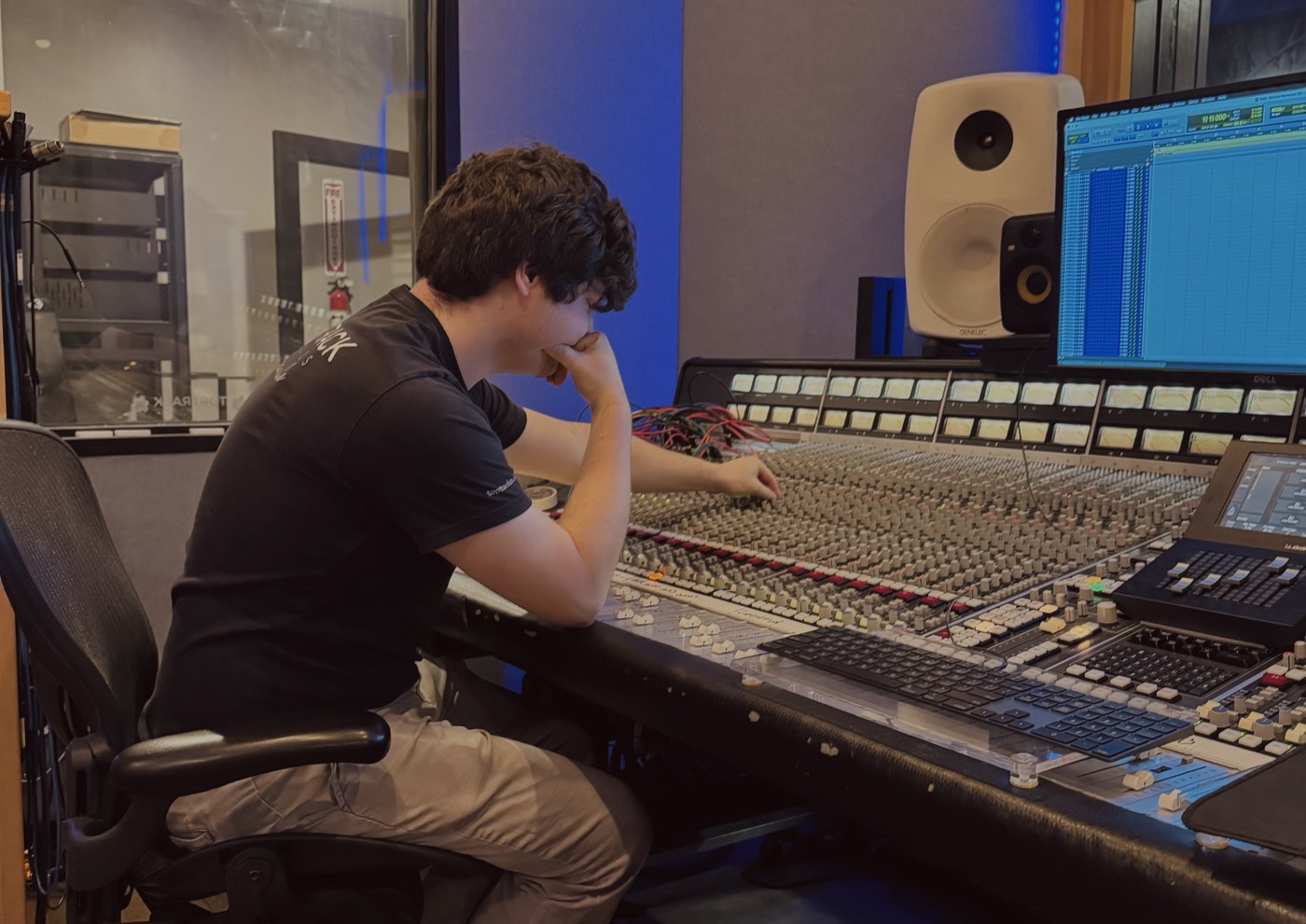 Drew Stratton working at a large-format mixing console in a recording studio